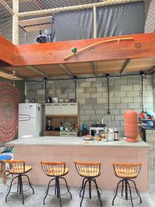 una cucina con quattro sedie e un bar con un bancone di Sítio Buscafé a Ibicoara