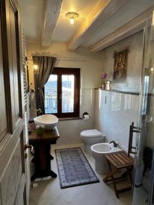 a bathroom with two sinks and a toilet and a window at Casale Sol Armonie in Codroipo +25 photos
