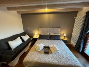 una camera da letto con un letto grande e un divano di Casale Sol Armonie a Codroipo Altre 19 foto