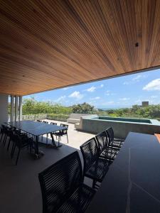 un groupe de tables et de chaises sur une terrasse dans l'établissement Luxury House VILLA MARIA, à Pipa