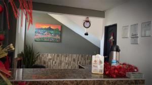 einen Tresen in einem Restaurant mit einer Uhr an der Wand in der Unterkunft Brisas de Uribia in Uribia