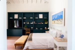 una camera con un letto bianco e una parete blu di Casa Flor a Punta del Este Altre 88 foto