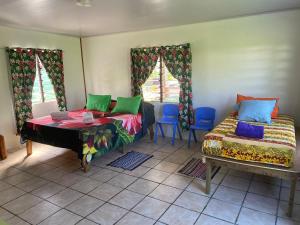 a room with two beds and a table and chairs at Punahere lodge Ohotu in Rangiroa