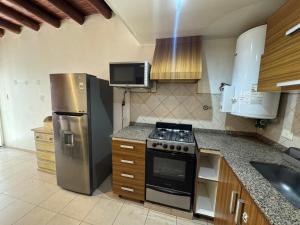 a kitchen with a stainless steel refrigerator and a stove at Cava del Sur in San Rafael