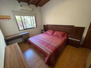 a bedroom with a bed and a desk and a window at Cava del Sur in San Rafael