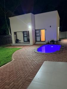 a swimming pool in the middle of a yard at night at Cathy & P Guesthouse in Hartbeespoort