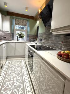 una cucina con mobili bianchi e una ciotola di mele sul bancone di Spinners View - NEW Renovated Apartment - Central Skipton & Parking a Skipton