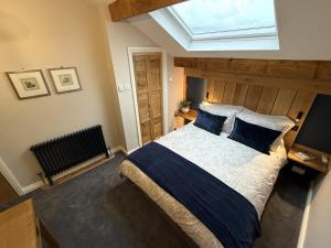 a bedroom with a large bed with a skylight at Spinners View - NEW Renovated Apartment - Central Skipton & Parking in Skipton