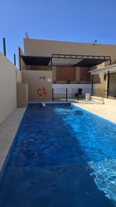 a large blue swimming pool in front of a building at Complejo Brisas Místicas in Las Grutas