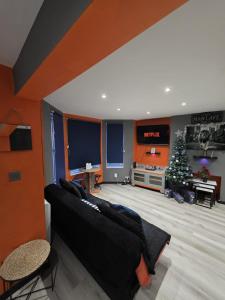 ein Wohnzimmer mit einer schwarzen Couch und einem Weihnachtsbaum in der Unterkunft Energy - 8ight Havens Folkestone in Folkestone + 51 Fotos