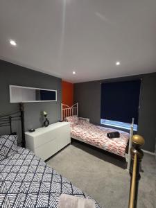 1 Schlafzimmer mit 2 Betten und einem großen Bildschirm in der Unterkunft Energy - 8ight Havens Folkestone in Folkestone