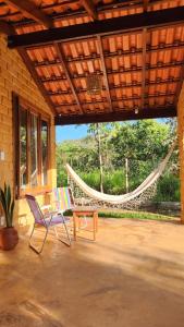 a patio with a hammock and two chairs and a table at Casa Pequi in Alexânia