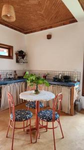a table with two chairs and a table with a plant on it at Casa Pequi in Alexânia +40 photos