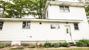 a white house with a white door at Cottage on Crystal Beach 3BR & BBQ in Fort Erie