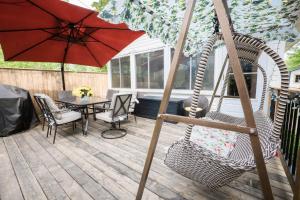 a patio with a swing and a table and an umbrella at Cottage on Crystal Beach 3BR & BBQ in Fort Erie