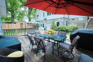 a table with chairs and a red umbrella on a deck at Cottage on Crystal Beach 3BR & BBQ in Fort Erie