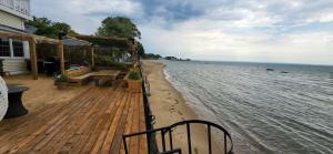 a wooden deck with a picnic table on the beach at Water Front Beach House - 3BR w BBQ & Sunset in Fort Erie