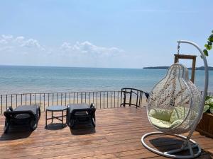 a swing sitting on a deck near the beach at Water Front Beach House - 3BR w BBQ & Sunset in Fort Erie