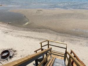 a wooden stairs leading to a beach with the ocean at Water Front Beach House - 3BR w BBQ & Sunset in Fort Erie
