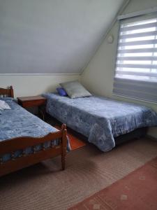 two beds in a room with a window at Búho Real Cityhouse in El Cerrillo