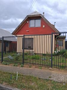 a fence in front of a red house at Búho Real Cityhouse in El Cerrillo