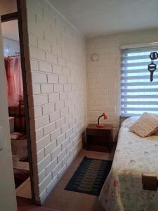 a bedroom with a bed and a brick wall at Búho Real Cityhouse in El Cerrillo