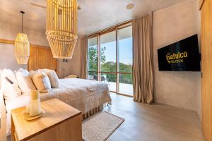 a bedroom with a bed and a large window at 3086 - TreeTop Villa in Tangolunda