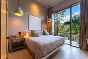 a bedroom with a bed and a large window at 3086 - TreeTop Villa in Tangolunda +39 photos