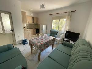 un soggiorno con un tavolo e una cucina di Casa Mia a Vlorë