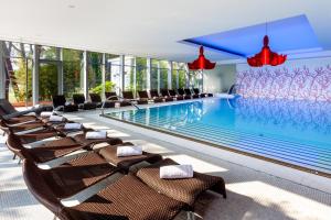 a hotel pool with chairs and a swimming pool at Hotel Coral Plava Laguna in Umag