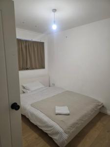 a bedroom with a bed with a towel on it at Spacious room in London +9 photos