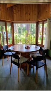 ein Esszimmer mit einem Holztisch und Stühlen in der Unterkunft Papacholo in Pinamar