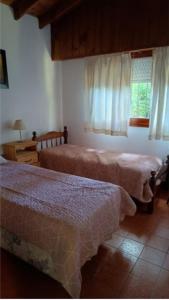 ein Schlafzimmer mit zwei Betten und einem Fenster in der Unterkunft Papacholo in Pinamar