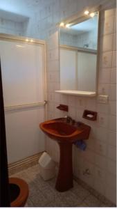 ein Badezimmer mit einem hölzernen Waschbecken und einem Spiegel in der Unterkunft Papacholo in Pinamar + 8 Fotos