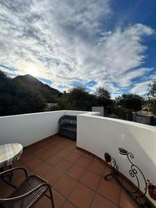 un balcon avec des chaises et une vue sur une montagne dans l'établissement Los Laureles, à Cafayate