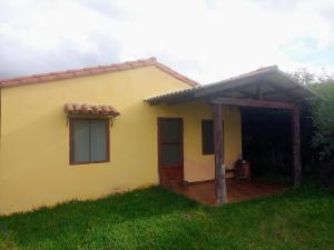 una casa gialla con una porta e un portico di Wasi a Samaipata