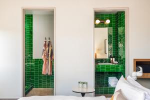 a bathroom with green tiled walls and a sink at Hotel Magdalena in Austin +72 photos