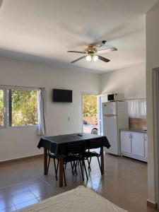 a dining room with a table and a ceiling fan at Brusa1 in Las Grutas