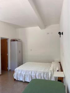 a small bedroom with a bed and a refrigerator at Brusa1 in Las Grutas