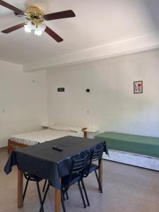 a room with a table and a bed with a ceiling fan at Brusa1 in Las Grutas