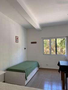 a white room with a bed and a window at Brusa1 in Las Grutas