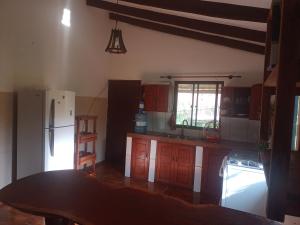 una cucina con frigorifero bianco e armadietti in legno di Wasi a Samaipata Altre 2 foto