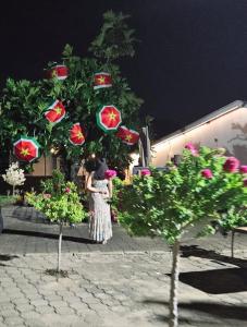 Una donna in piedi di fronte a un albero di Natale di The Blue Donkey a Paramaribo