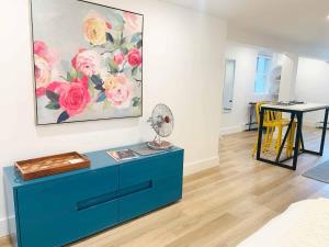 a blue dresser in a living room with a painting at Fresh Modern Garden Level Kittery Studio in Kittery