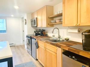 a kitchen with wooden cabinets and a sink at Fresh Modern Garden Level Kittery Studio in Kittery
