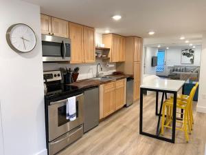 a kitchen with a table and a clock on the wall at Fresh Modern Garden Level Kittery Studio in Kittery
