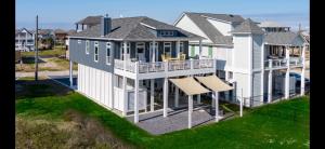a large white house with a porch and a swing at Perfect Beach Getaway Home! in Crystal Beach