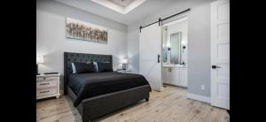 a bedroom with a black bed and a dresser and a bathroom at Perfect Beach Getaway Home! in Crystal Beach