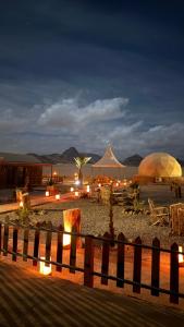 Eine Gruppe von Zelten und Tischen an einem Strand bei Nacht in der Unterkunft Rum Royal Dunes Camp & tour in Wadi Rum + 125 Fotos