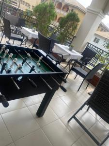 een pingpongtafel op een balkon met tafels en stoelen bij Trevors Home Place in Lagos